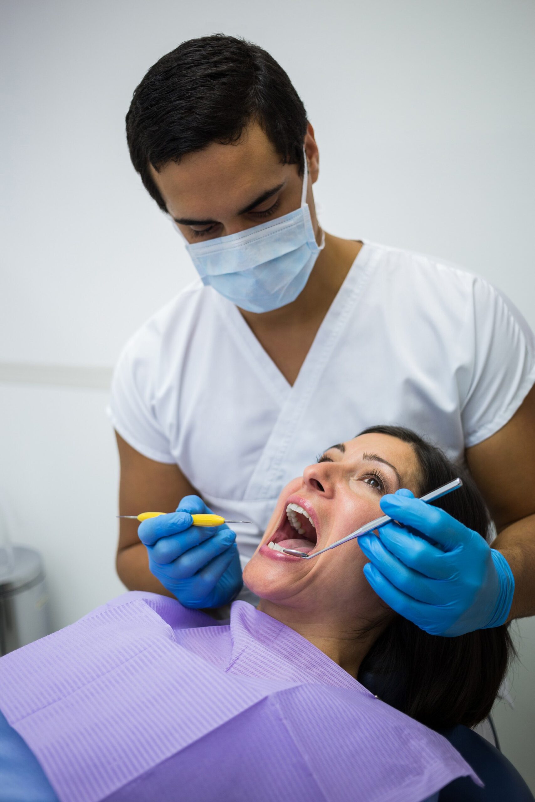 dentist examining female patient teeth